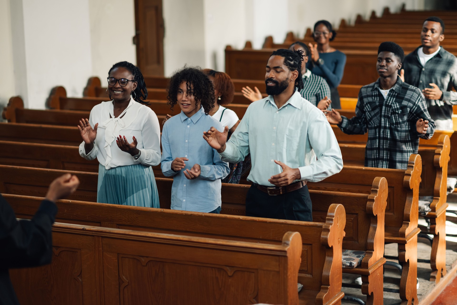 Congregation standing and praying with arms raised in church