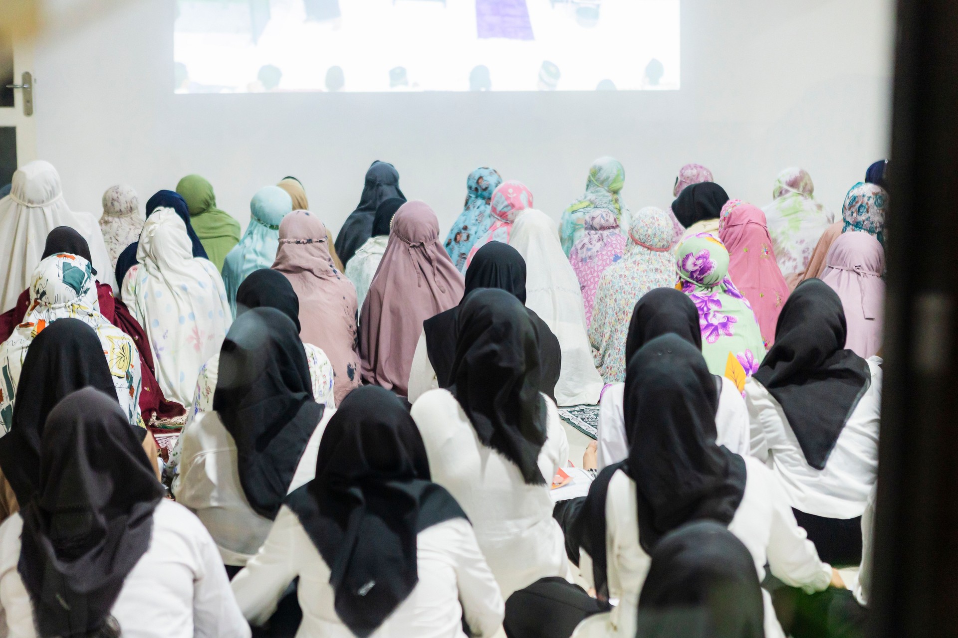 Indonesian women learning silat martial art from video projection