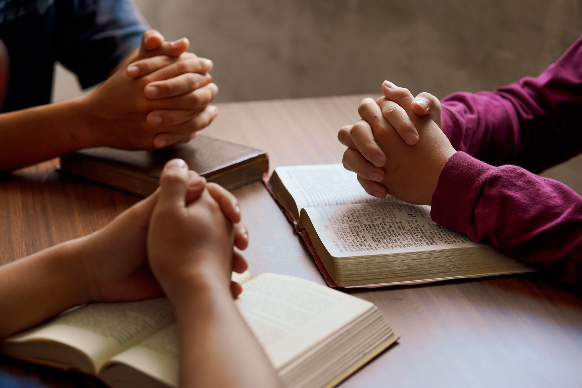 “Group Bible study with hands in prayer, reflecting spiritual connection, community, and meditation.”